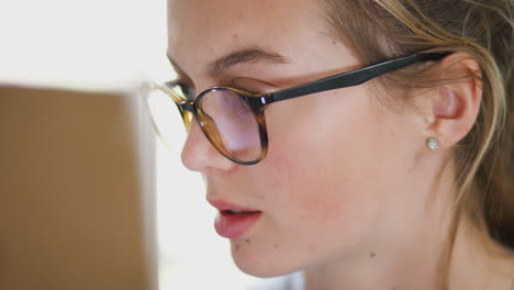 close up on face of female teenage artist working behind easel