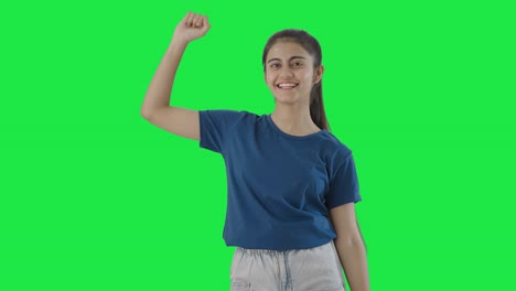 una adolescente india feliz bailando y disfrutando de la pantalla verde