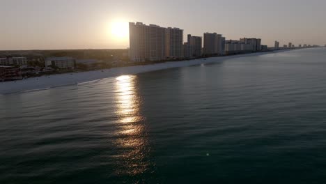 sunrise in panama city beach, florida showing hotels and gulf of america with drone video moving right to left.