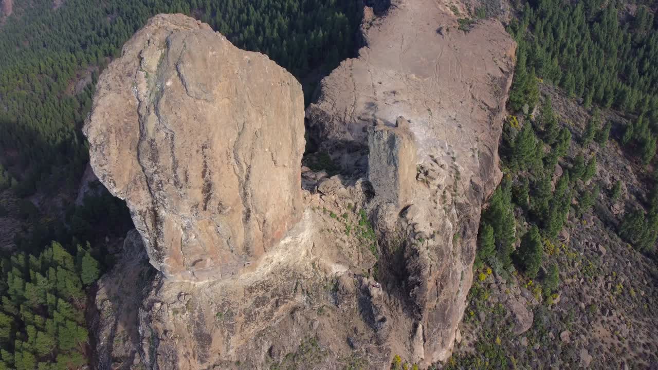 Drone above and panning down to Roque Nublo, huge volcanic monolith perched on top of Gran Canaria, Spain