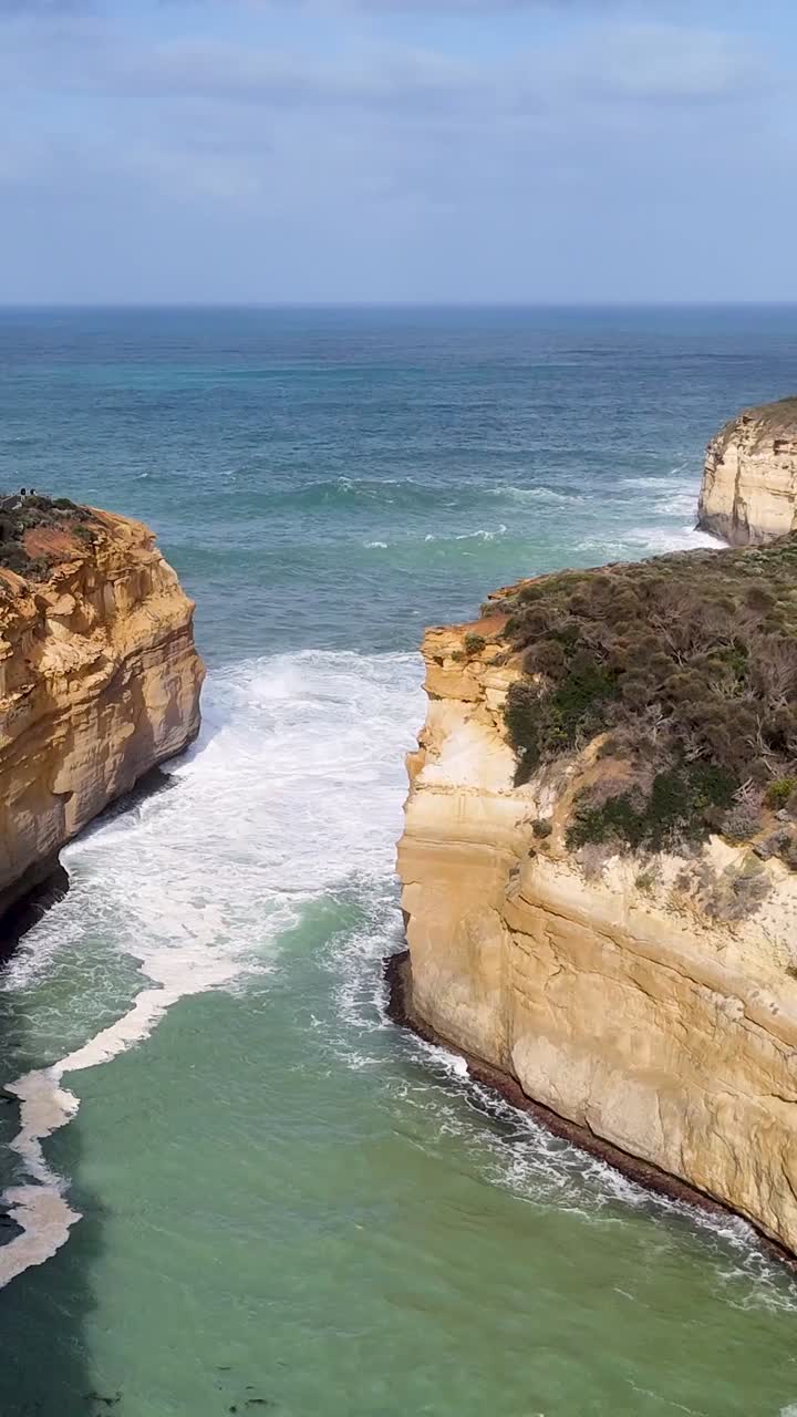Aerial perspective of dramatic limestone cliffs and crashing waves in a narrow coastal gorge