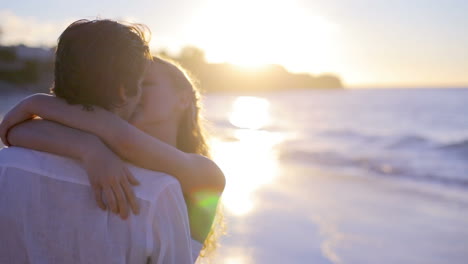 Couple-turning-and-kissing-during-the-sunset-at-the-beach