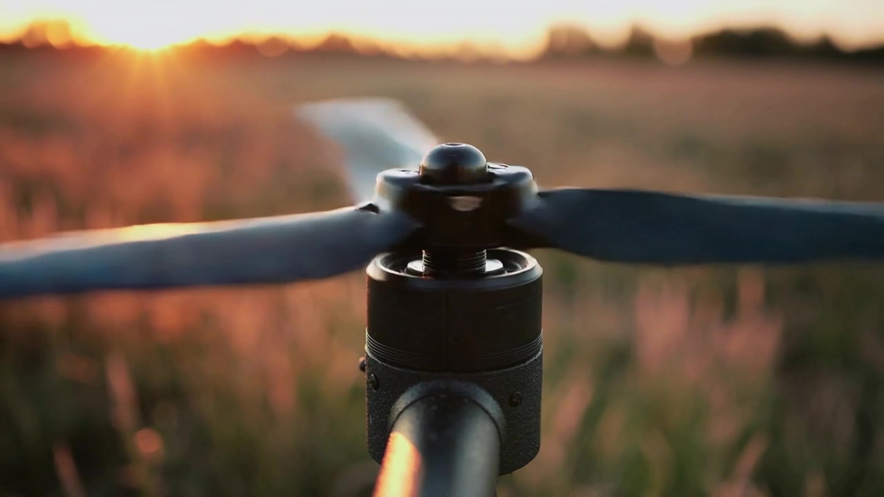 Motor powering two-blade propeller spinning up to cruise speed in meadow for takeoff, golden bokeh