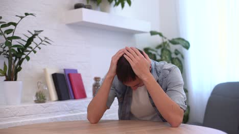 joven pensativo y serio estudiante escritor sentado en el escritorio de la oficina de casa con una computadora portátil pensando en la inspiración búsqueda de soluciones a problemas ideas perdidas en pensamientos concepto soñando mirando hacia otro lado