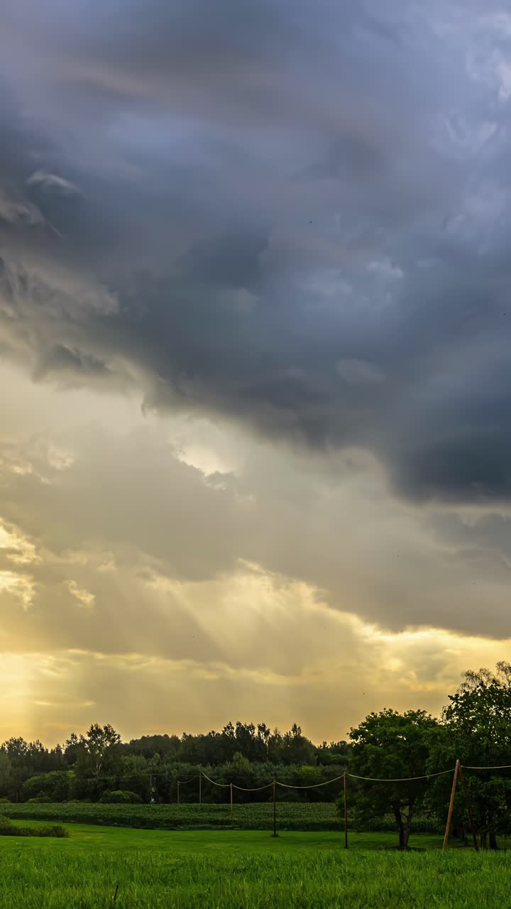 Awan badai gelap bergerak cepat melintasi lanskap hijau