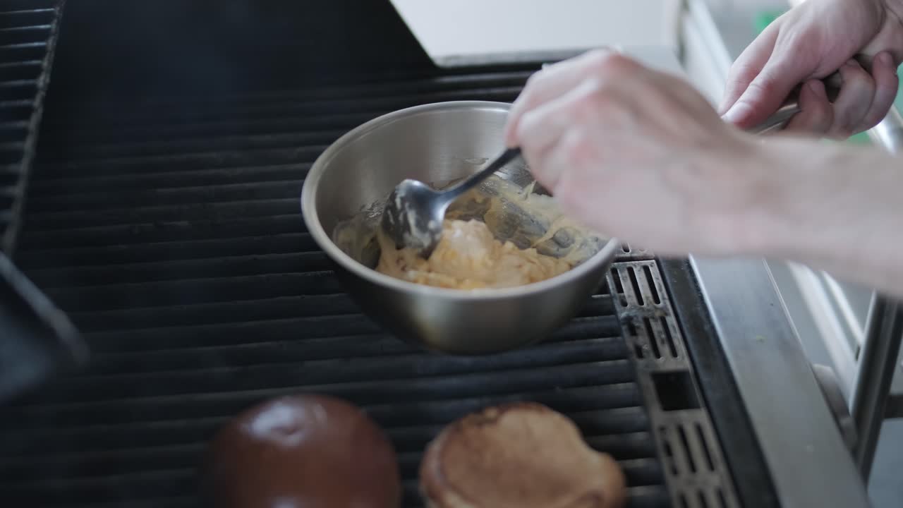 Tilbereder en saus til burgere på en grill