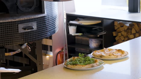 chef adding arugula on pizza at restaurant