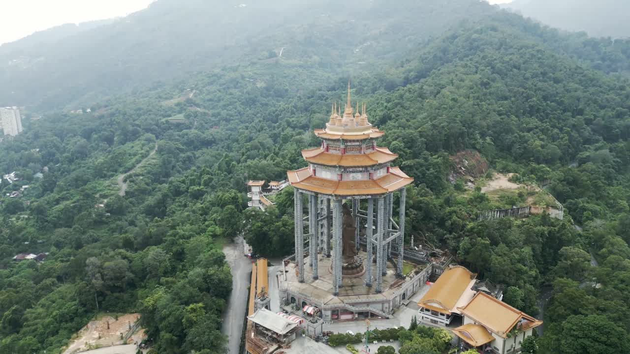 Aerial View of a Large Buddhist Statue and Temple on a Mountain