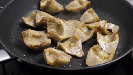 cocinando alcachofes en la sartén. primer plano