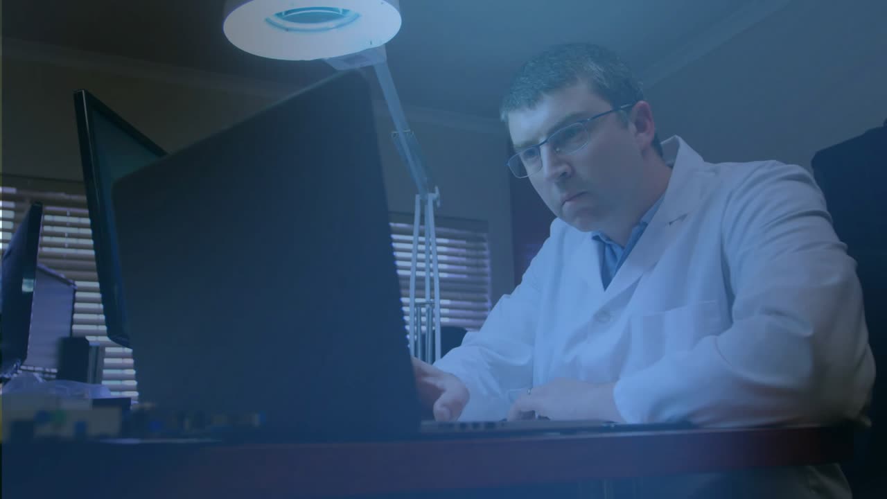 Man in lab coat leaning at laptop reviewing docs, holograms overlaying monitors for research