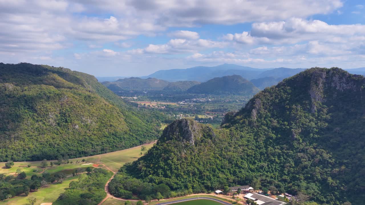 Sorvolo di droni su montagne di calcare verde e un resort di golf di lusso in una giornata luminosa