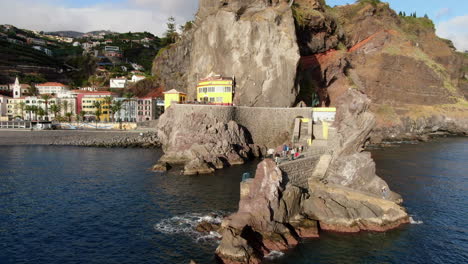 Toma-Aérea-En-órbita-Al-Puente-Y-La-Ciudad-Ponta-Do-Sol-En-La-Isla-De-Madeira-En-Un-Día-Soleado