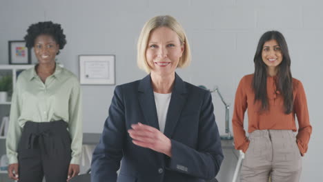 portrait of smiling female multi-racial business team standing in office