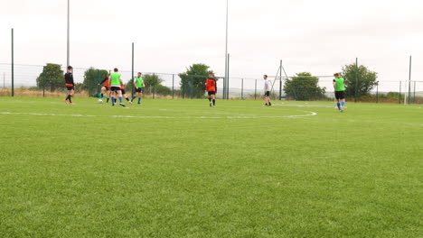 practicing soccer on field, players wearing colorful jerseys, preparing for match