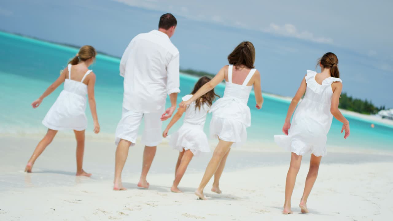 카우카시안 가족은 열대 바다의 해변에서 함께합니다.