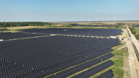 drone fly above solar panel photovoltaic base station with wind mill for green energy production at distance