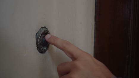 hand ringing the doorbell