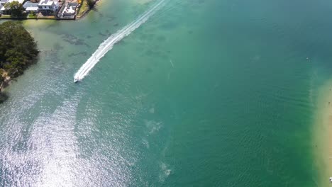 Wakeboarding-En-Verano---Wakeboarder-Remolcado-Detrás-De-La-Lancha-Motora-Con-Retrolavado---Agua-Azul-Brillante-En-Tallebudgera-Creek---Queensland,-Australia