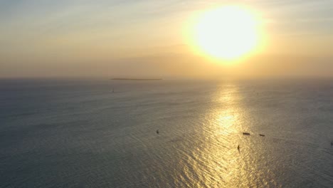 amplia vista de los barcos en el océano y la isla y el sol