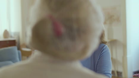 slow motion of aged woman in mask talking with doctor at home