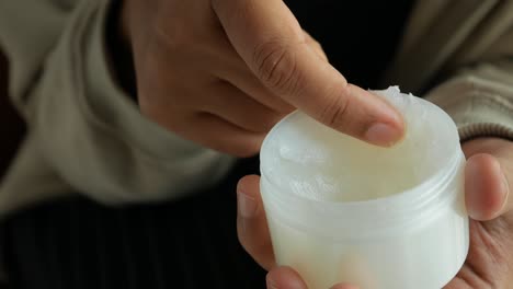 a person applying cream to their hand