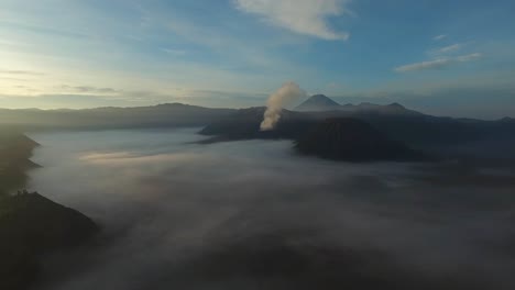 disparo de dron moviéndose hacia el volcán bromo, retumbando y humeando