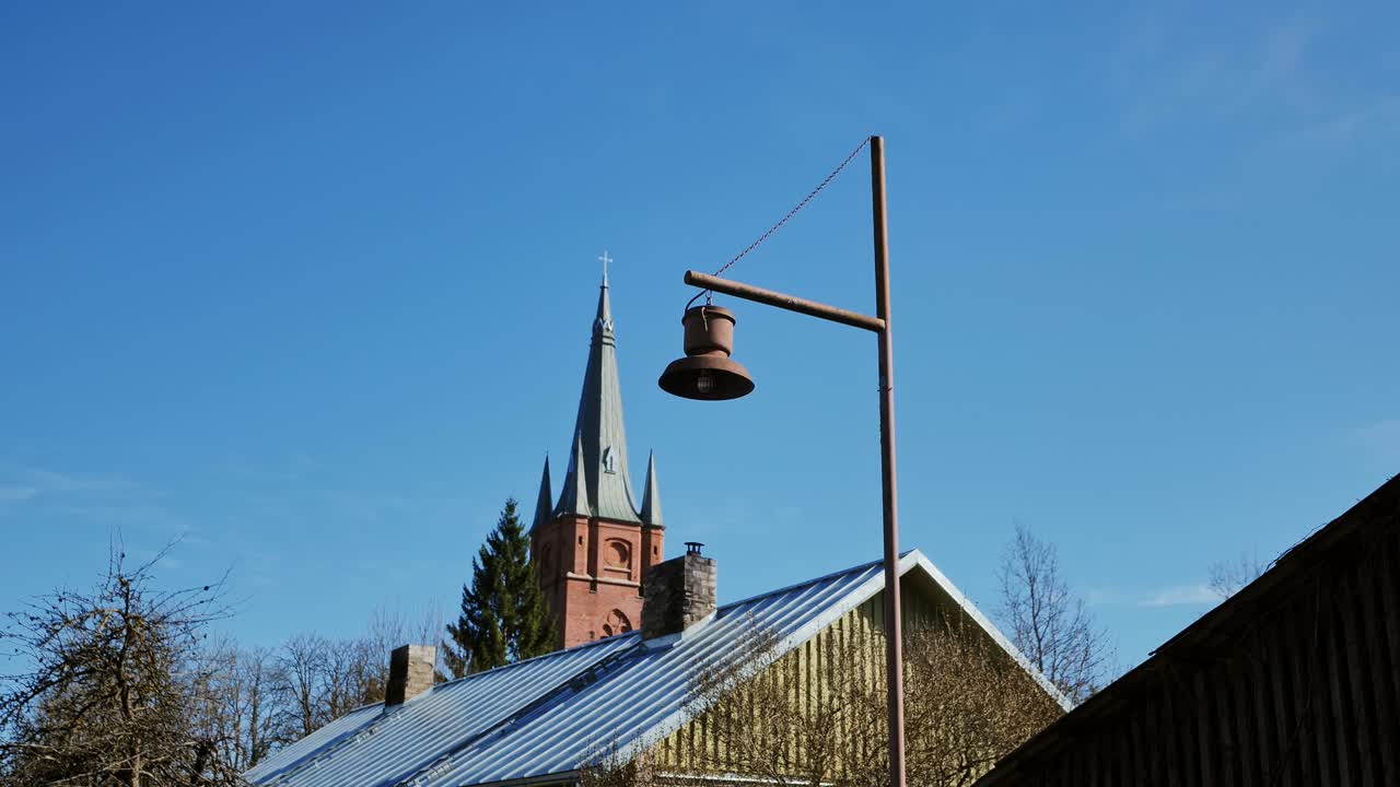 Scenic view of Kuldīga’s St. Anne’s Church steeple behind village rooftops 4K