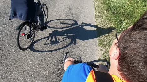 cyclist wearing an orange vest rides his bike