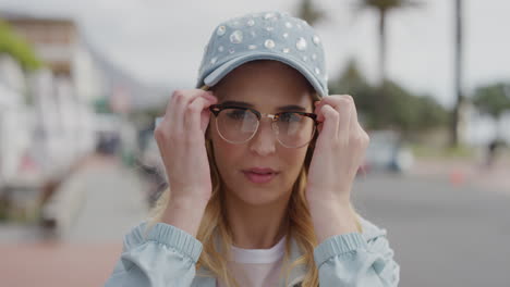 retrato de una linda mujer rubia geek sonriendo alegremente con gafas disfrutando de la playa soleada