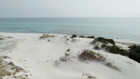 video aéreo de drones de dunas de arena en el mar cerca de la playa en el mediterráneo, cerdeña, capo comino