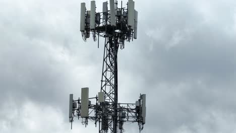 proud american flag waves in wind before a cell tower rising into a cloudy sky. powerful symbol of freedom, modern communication, and technological spirit of the united states