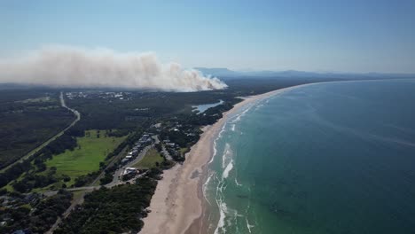 humo de la quema de matorrales costeros - incendio de matorrales junto a la playa de north belongil en la bahía de byron, nsw, australia
