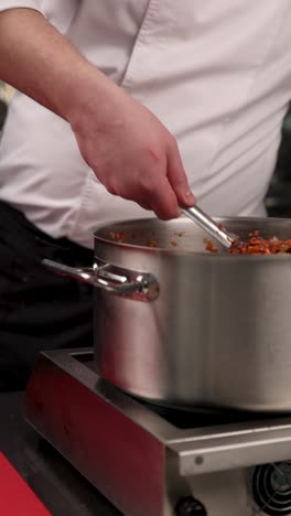 chef stirring food in a pot