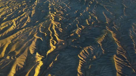 paysage désertique doré, vue aérienne de la terre stérile sèche et de la formation rocheuse butte au coucher du soleil, hors de ce paysage de planète, inclinaison vers le haut du drone