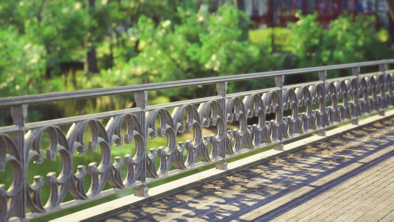 Stylish wrought iron fence casting elongated shadows on stone walkway