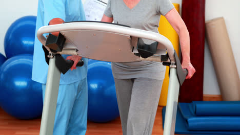 physiotherapeut zeigt dem patienten, wie man auf dem laufband läuft