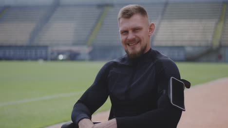 smiling disabled athlete in a wheelchair at a stadium