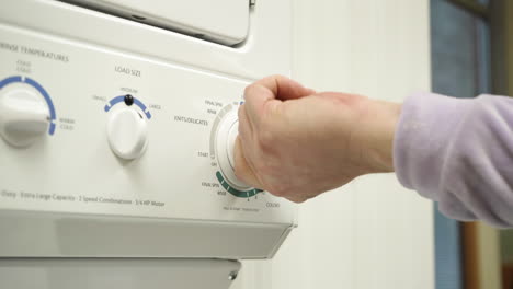 adjusting settings on washing machine in laundry room