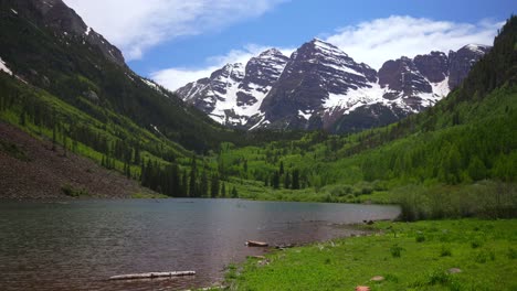 Spring summer Maroon Lake trail Maroon Bells Wilderness morning sunny blue sky clouds Aspen Snowmass Colorado Elk Range Rocky Mountains White River Maroon Creek National Forest melting snow fields