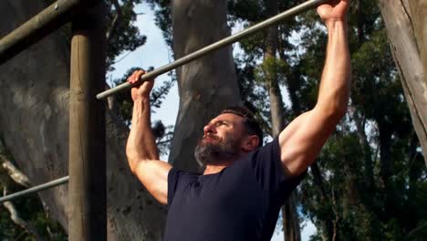 hombre realizando pull-ups en el campamento de entrenamiento