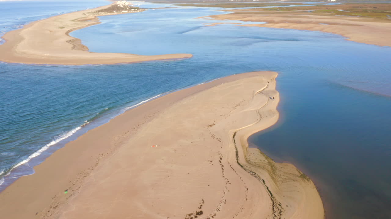 vista aérea de un estuario costero con banco de arena y olas
