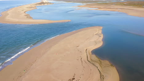 aerial view of a coastal estuary with sandbar and waves