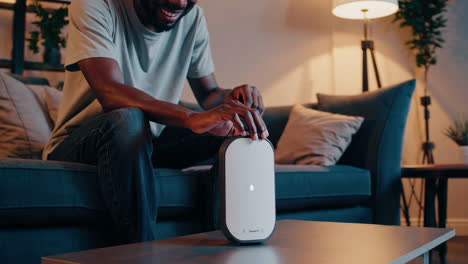 man interacts with a smart home device in the living room