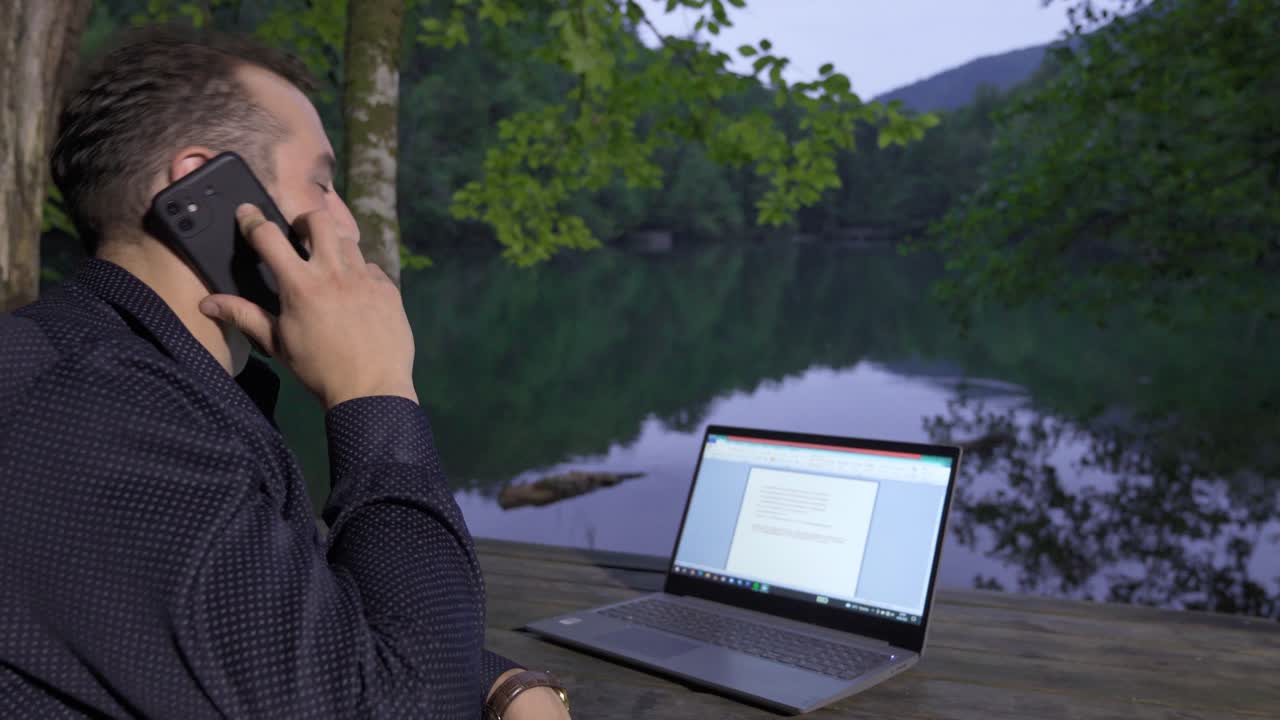 비즈니스맨이 호수에 맞서 사업을 하고 있습니다.