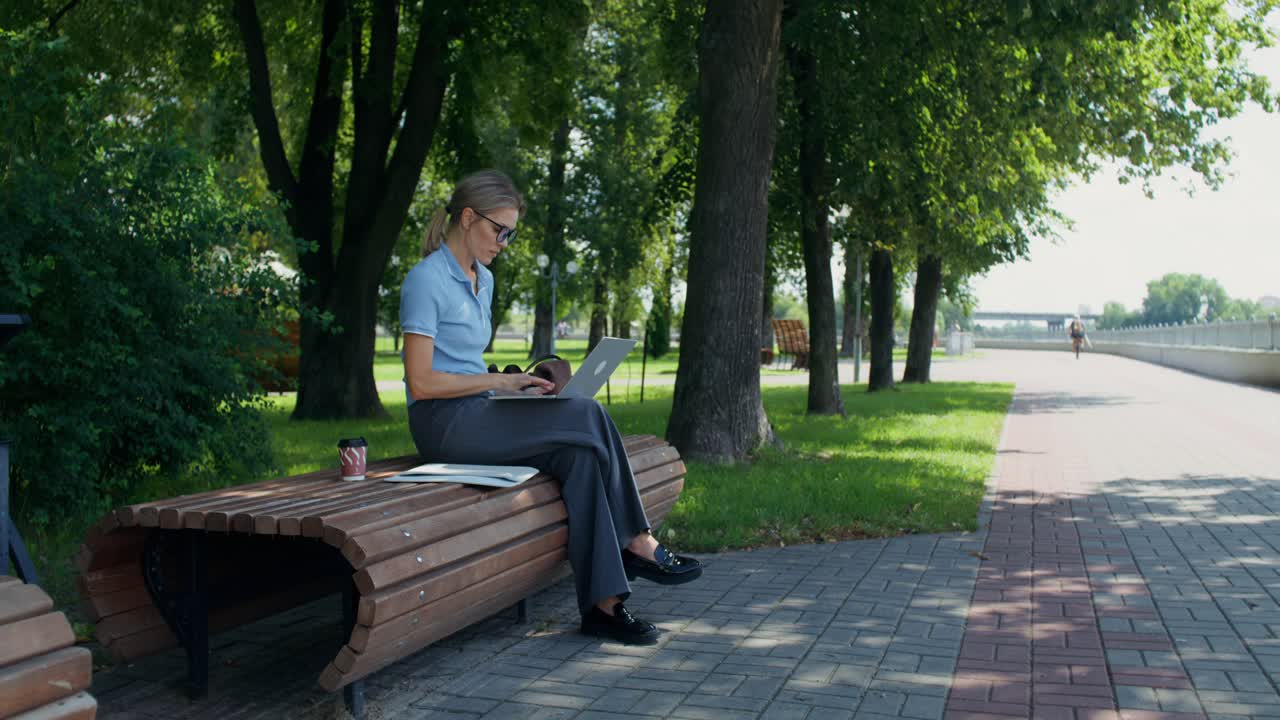 Mulher de negócios trabalhando no laptop no parque