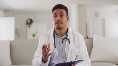 Portrait-of-happy-hispanic-male-doctor-having-interview-with-patient-at-home