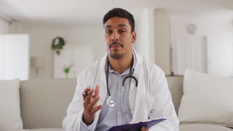 Retrato-De-Un-Feliz-Médico-Hispano-Que-Se-Entrevista-Con-Un-Paciente-En-Casa