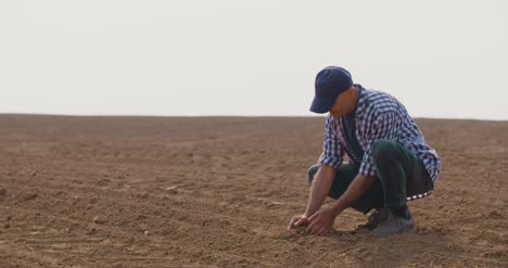 Manos-Del-Agricultor-Sosteniendo-Y-Vertiendo-Tierra-Orgánica-1