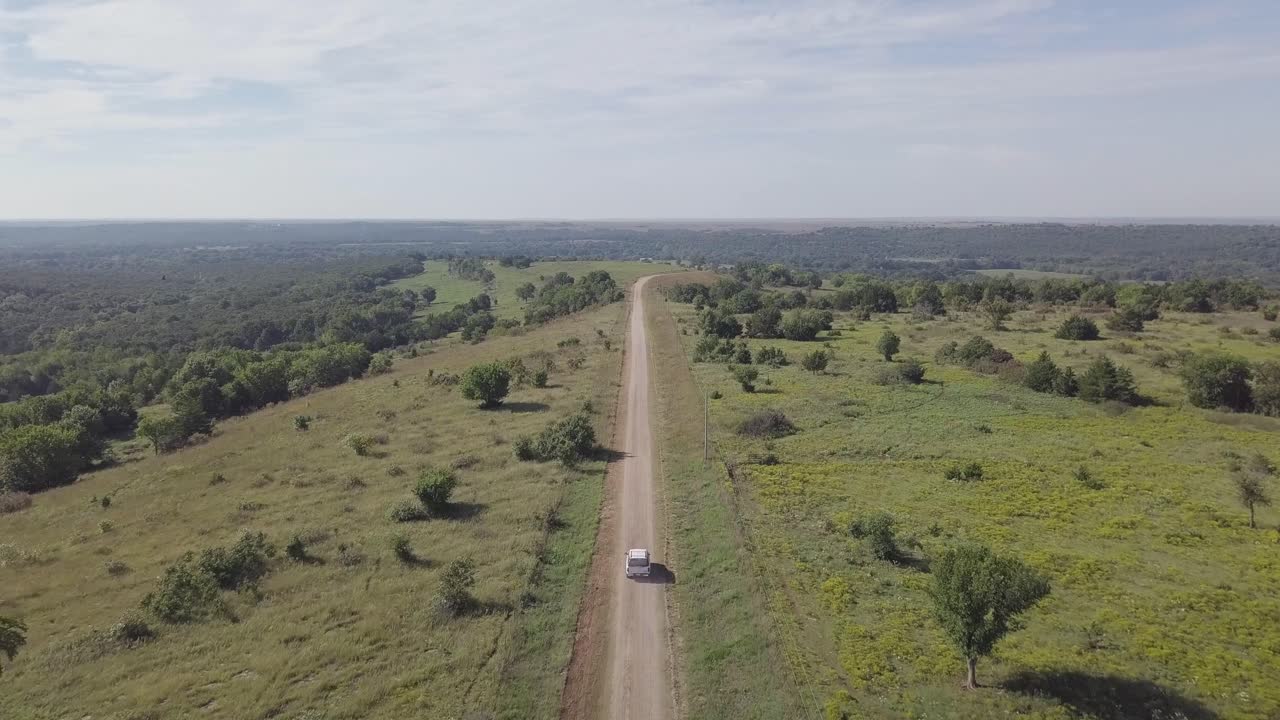 imágenes aéreas de drones volando sobre un suv conduciendo por un camino de tierra del país