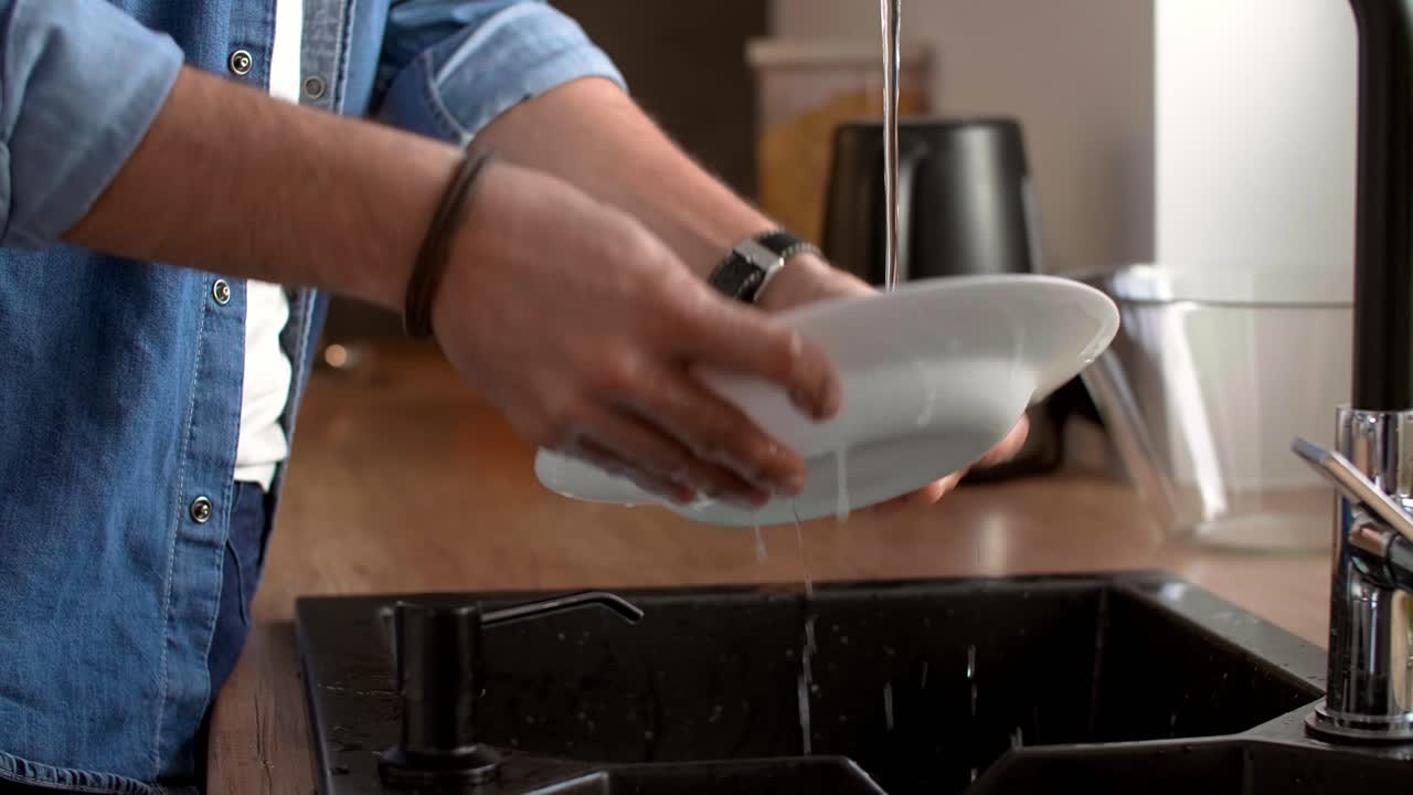 Man's hands washing dishes in the kitchen